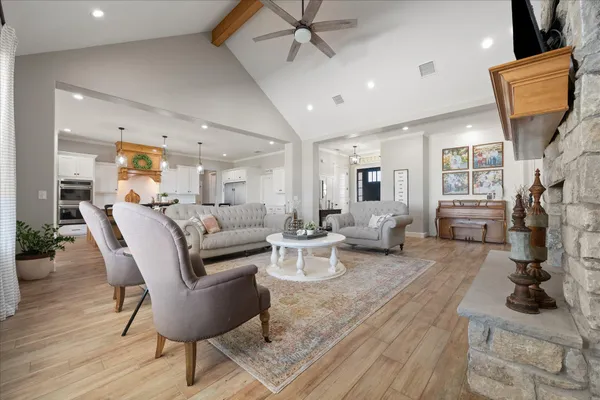 a large kitchen with stainless steel appliances kitchen island granite countertop a sink dishwasher a stove and a dining table with wooden floor