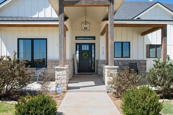 a view of a hallway with entryway wooden floor and front door