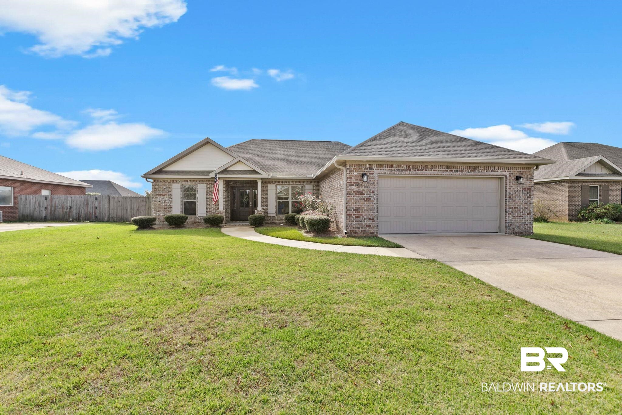View of front of property with brick siding, roof with shingles, concrete driveway, a garage, and covered porch