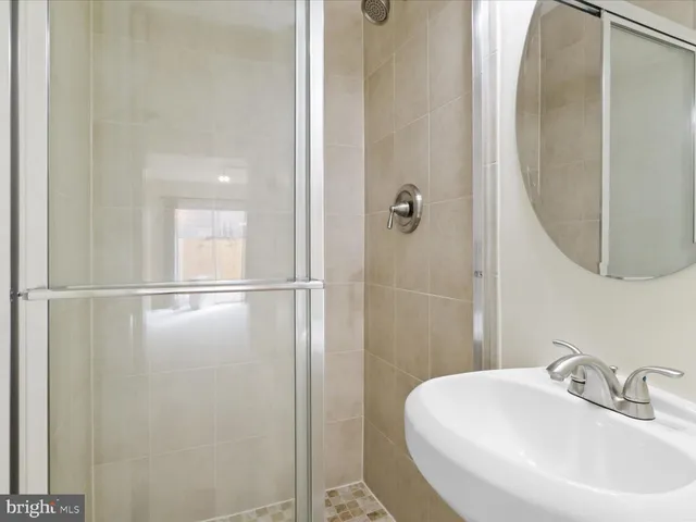 a bathroom with a sink a glass door and a mirror