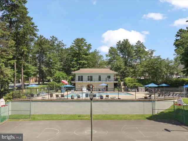 a swimming pool view with a outdoor seating and a forest