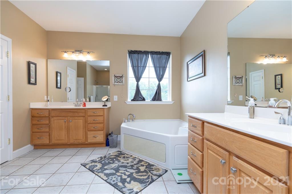 196 Cedar Grove Road York, SC 29745 - Photo 31 of 45 a bathroom with a sink a vanity a mirror and a bathtub