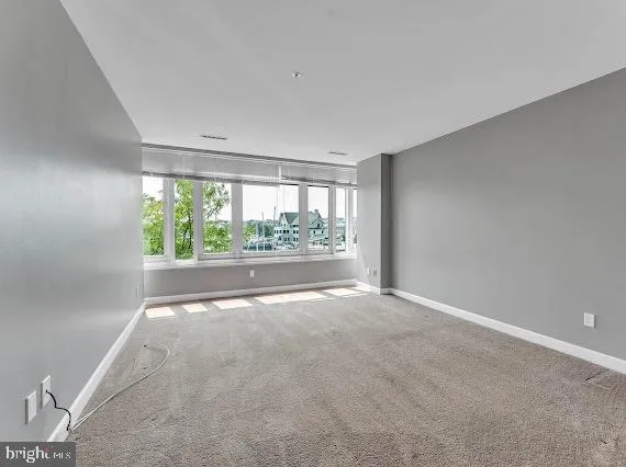 an empty room with large windows and outdoor space