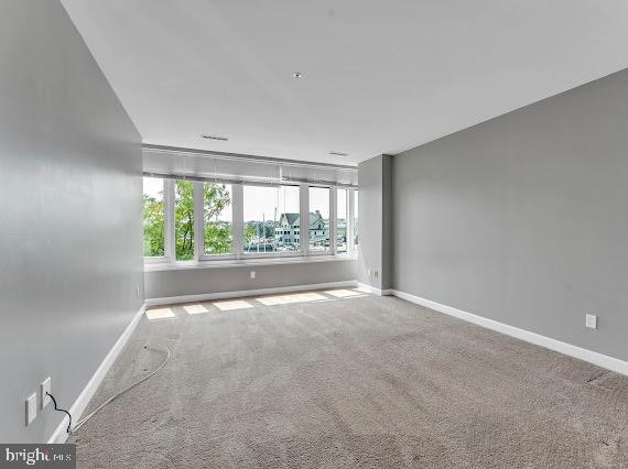 100 Harborview Drive, Unit 202 Baltimore, MD 21230 - Photo 10 of 25 an empty room with large windows and outdoor space
