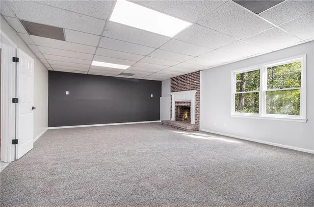a view of empty room with a fireplace and windows