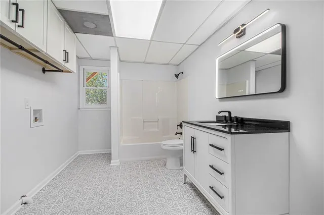 a bathroom with a granite countertop sink a toilet and a mirror