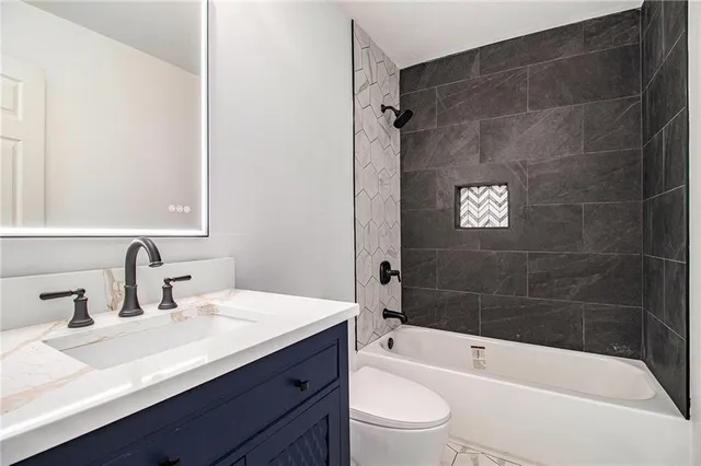 a bathroom with a sink a toilet a bathtub and shower