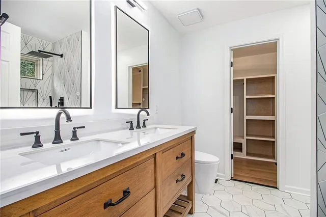 a bathroom with a sink a toilet and a mirror
