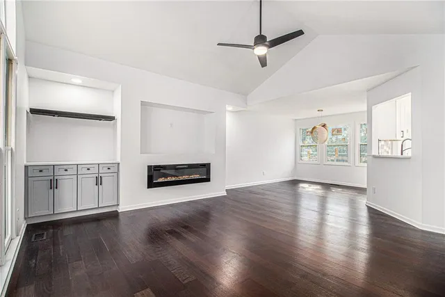 a view of a kitchen with stainless steel appliances wooden floor and a fireplace