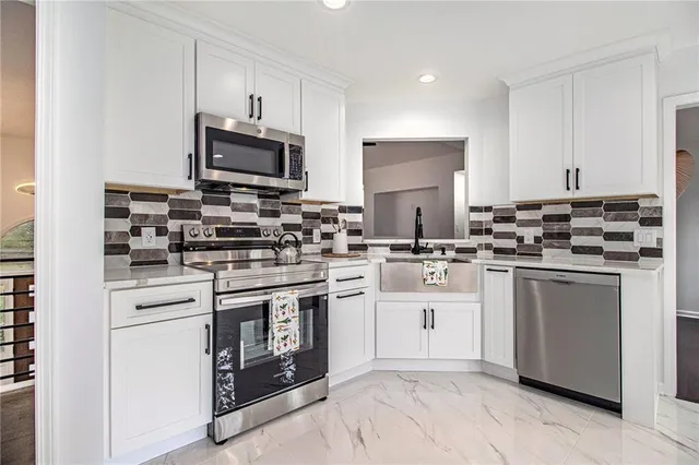 a kitchen with white cabinets stainless steel appliances and sink