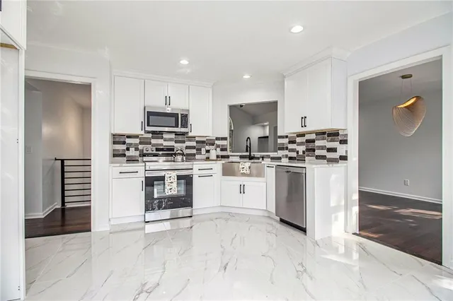 a kitchen with white cabinets and stainless steel appliances