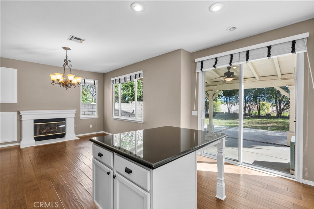 25558 Fitzgerald Avenue Stevenson Ranch, CA 91381 - Photo 16 of 55 a kitchen with granite countertop a table chairs and a fireplace