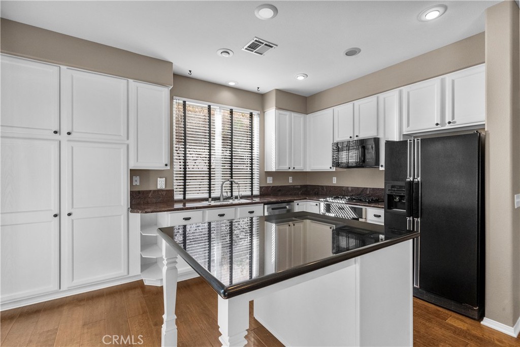 25558 Fitzgerald Avenue Stevenson Ranch, CA 91381 - Photo 19 of 55 a kitchen with kitchen island a counter space a sink a refrigerator and cabinets