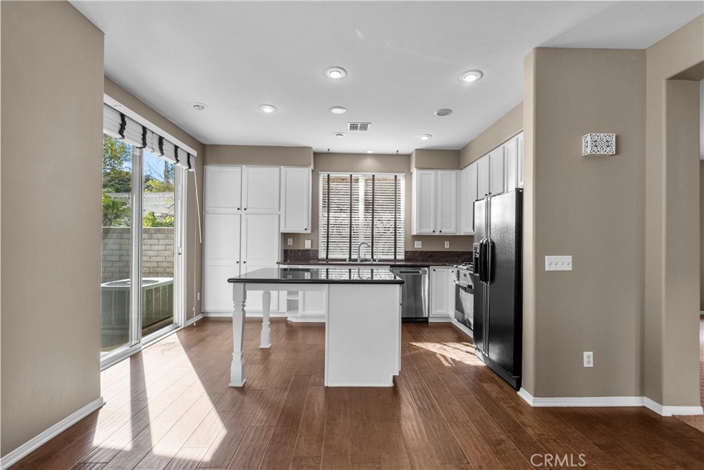 25558 Fitzgerald Avenue Stevenson Ranch, CA 91381 - Photo 23 of 55 a kitchen with kitchen island granite countertop wooden floors and stainless steel appliances