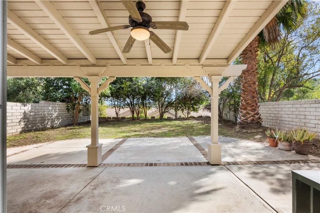 25558 Fitzgerald Avenue Stevenson Ranch, CA 91381 - Photo 48 of 55 a view of a porch with a table and chairs under an umbrella with a small yard