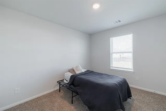 a bed sitting in a bedroom next to a window