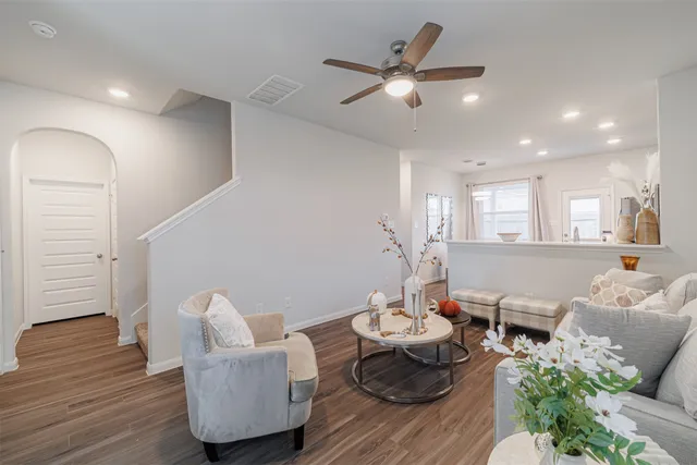 a living room with furniture and a wooden floor