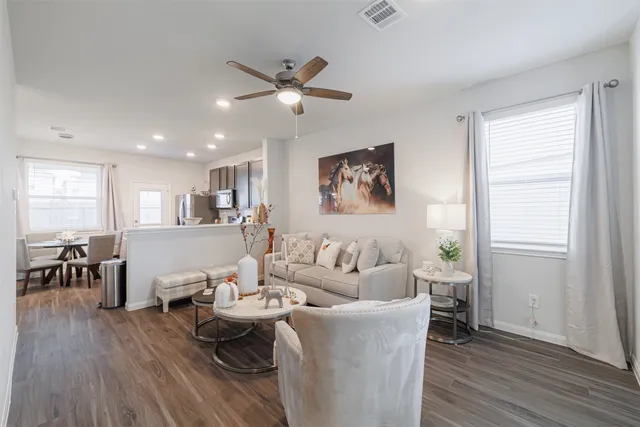 a living room with furniture and a wooden floor