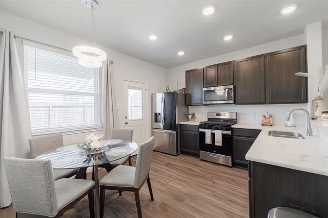 a kitchen with a refrigerator stove a sink and dishwasher with wooden floor