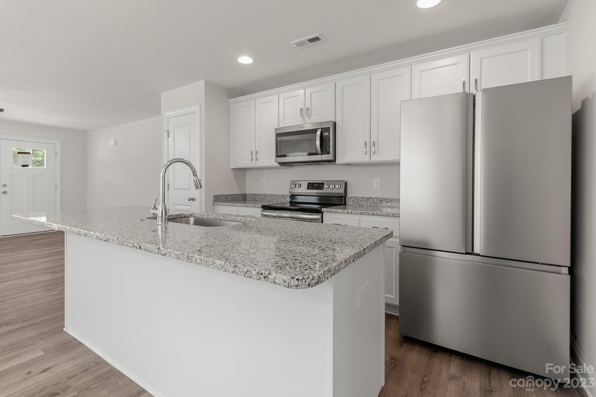 318 Springhill Lane Maiden, NC 28650 - Photo 12 of 40 a kitchen with stainless steel appliances granite countertop a refrigerator a sink a stove a microwave and cabinets