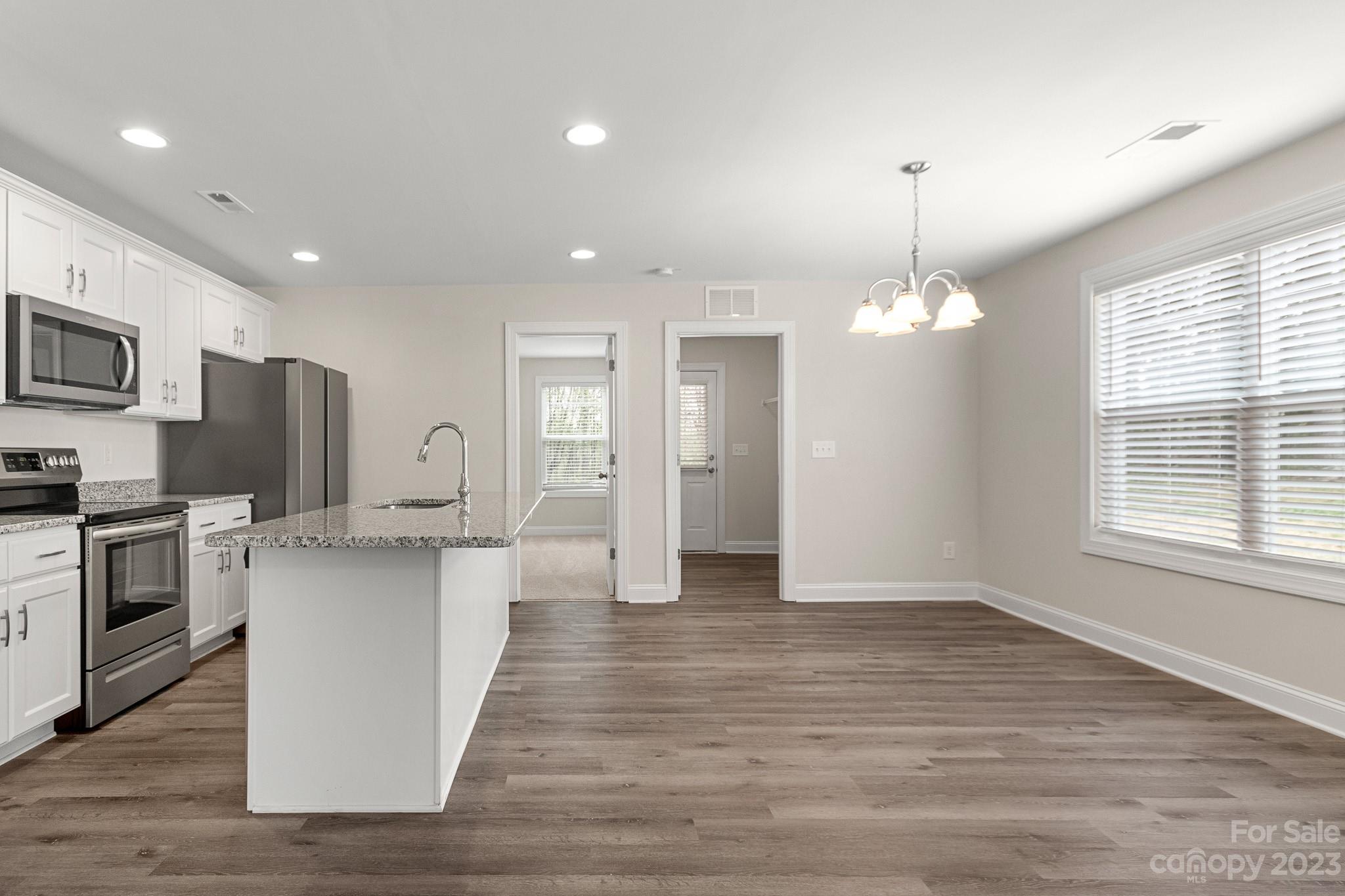 318 Springhill Lane Maiden, NC 28650 - Photo 10 of 40 a kitchen with stainless steel appliances granite countertop a refrigerator stove a sink dishwasher a oven with white cabinets and wooden floor