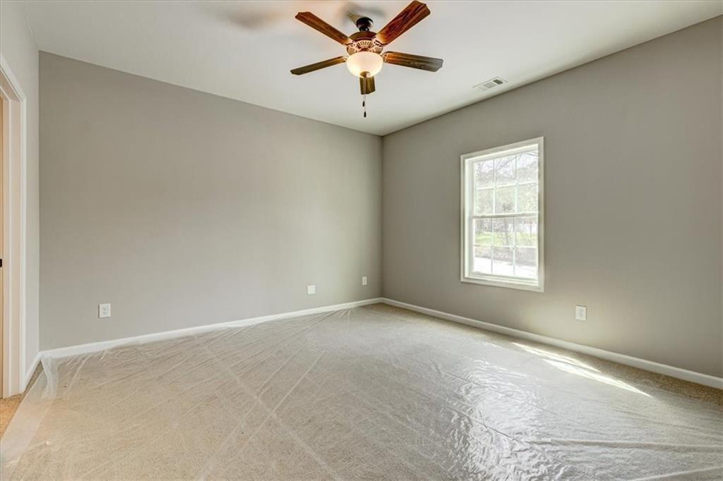 207 Loftis Road Temple, GA 30179 - Photo 10 of 14 an empty room with a window and a ceiling fan