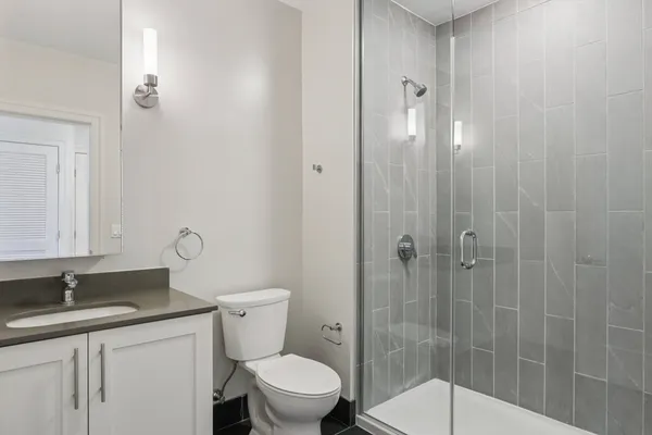 a bathroom with a granite countertop sink toilet and shower
