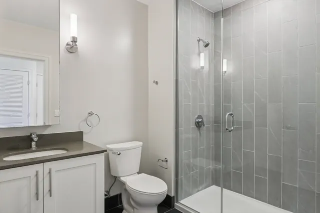 a bathroom with a granite countertop sink toilet and shower