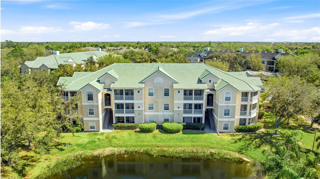 5110 Northridge Road, Unit 203 Sarasota, FL 34238 - Photo 1 of 1 a view of a big house with a big yard and large trees