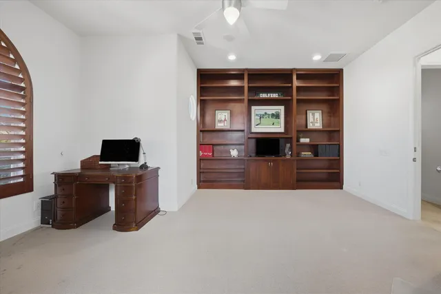 a view of a workspace with furniture and a window