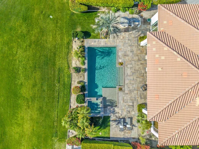 a view of a table and chairs under an umbrella in a garden