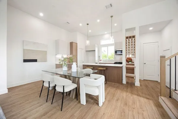 a kitchen with a table chairs refrigerator and microwave