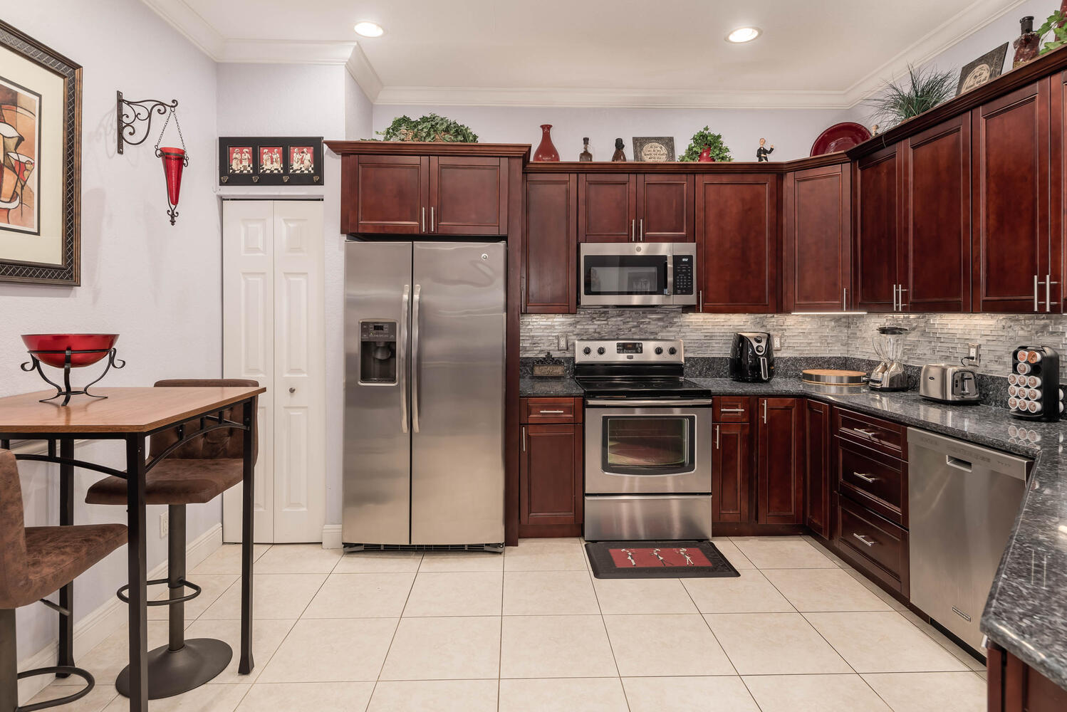 16055 Sims Road, Unit 102 Delray Beach, FL 33484 - Photo 12 of 60 a kitchen with stainless steel appliances granite countertop a refrigerator and a stove top oven
