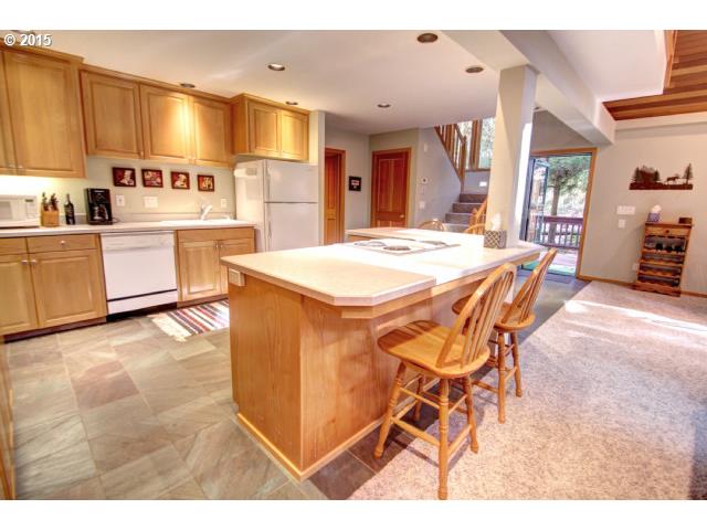 70385 East Zig Zag River Road Rhododendron, OR 97049 - Photo 8 of 16 a kitchen with stainless steel appliances kitchen island granite countertop a table chairs sink and cabinets