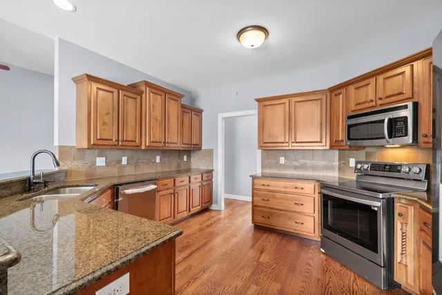 a kitchen with stainless steel appliances granite countertop a sink stove and microwave