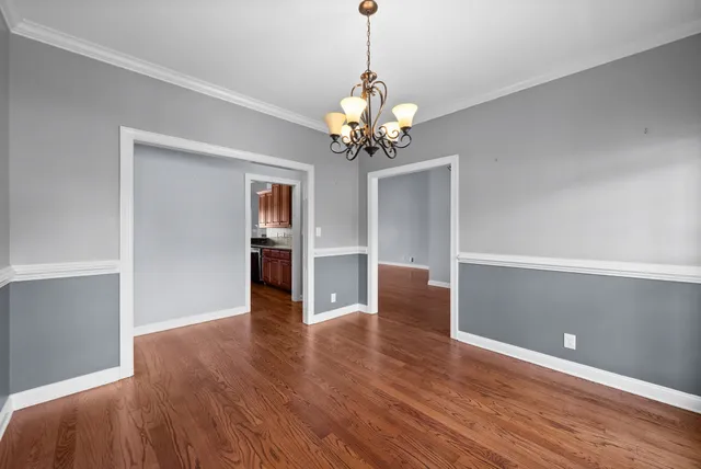 a view of a room with wooden floor and chandelier