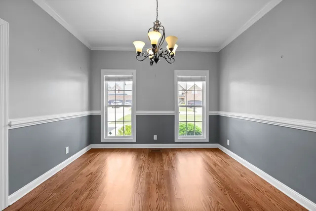 a view of a room with wooden floors and chandelier