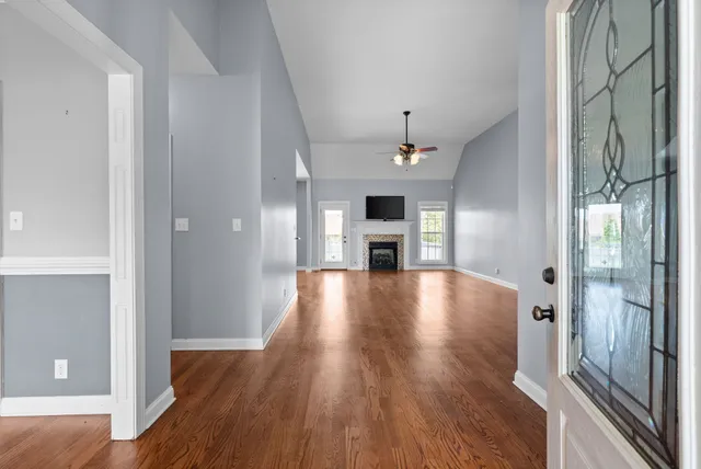 a view of empty room with wooden floor and fireplace