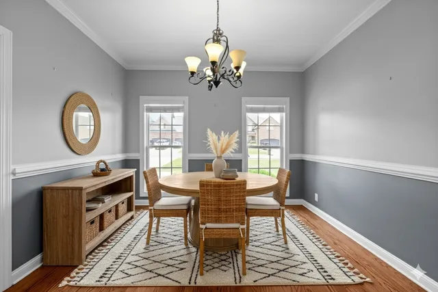 a view of a dining room with furniture a chandelier and wooden floor