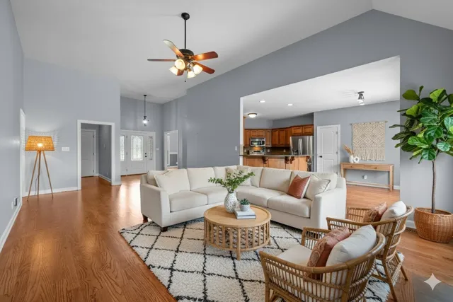 a living room with furniture a chandelier and a wooden floor