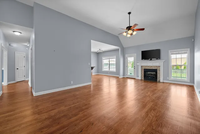 a view of a livingroom with a fireplace wooden floor and a window