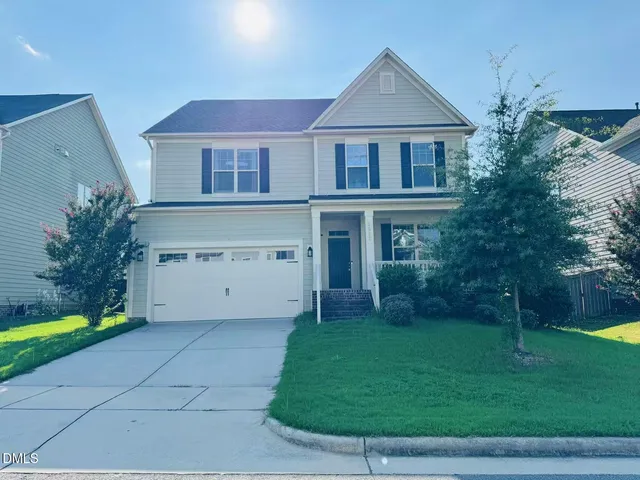 a front view of a house with a yard and trees