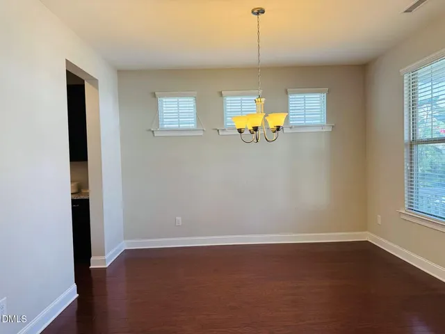 an empty room with windows and wooden floor