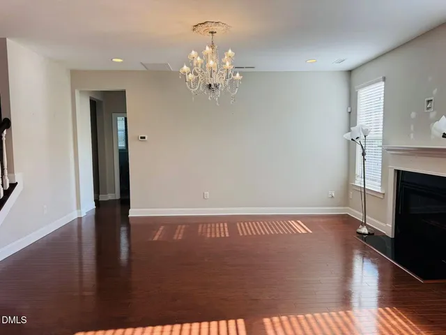 a view of empty room with wooden floor and fireplace