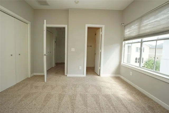 an empty room with windows and closet