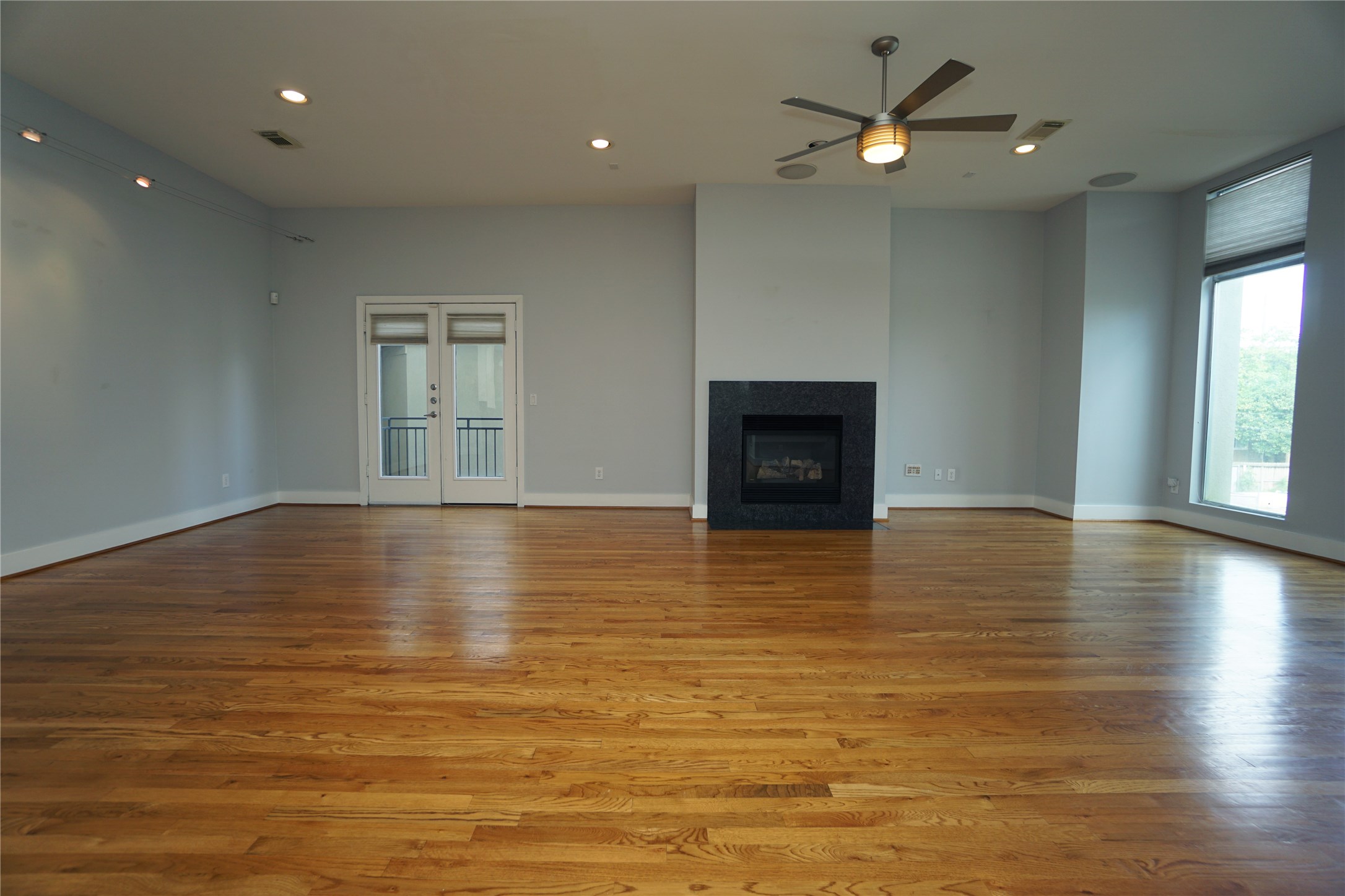 4313 Feagan Street, Unit A Houston, TX 77007 - Photo 4 of 20 an empty room with wooden floor and a fireplace