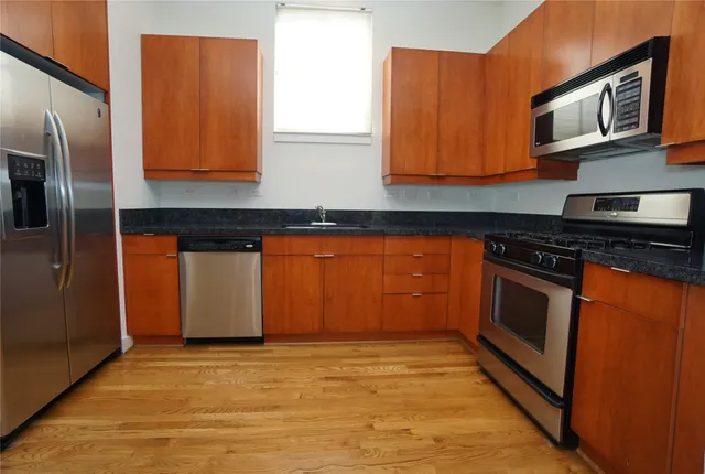 a kitchen with stainless steel appliances granite countertop a stove a microwave and a refrigerator