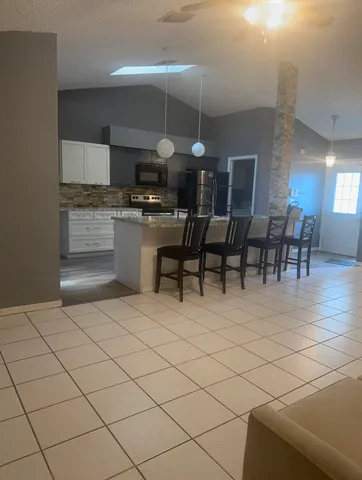 a open kitchen with stainless steel appliances kitchen island granite countertop a sink and cabinets