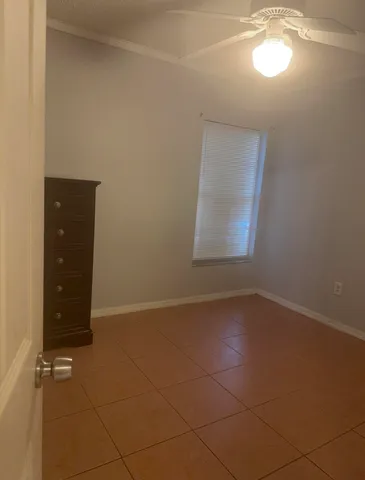 an empty room with a bathroom and a window