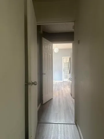 a view of a hallway with wooden floor